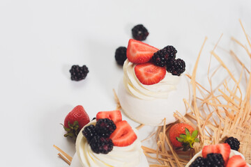 Dessert with berries on a meringue with cream.