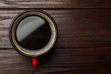 Cup of aromatic coffee on wooden table, top view. Space for text