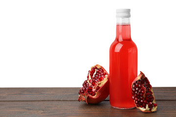 Delicious kombucha in glass bottle and pomegranate on wooden table against white background, space...