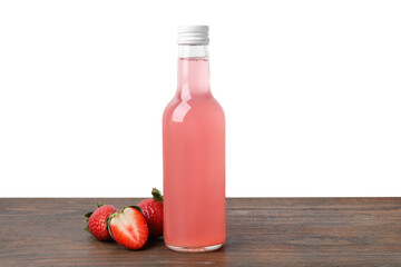 Delicious kombucha in glass bottle and strawberries on wooden table against white background