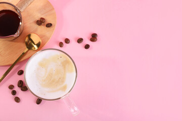 Cup of fresh coffee and beans on pink table, flat lay. Space for text