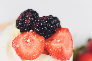 Dessert with berries on a meringue with cream.