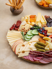 Cheese plate with different types of cheese, fruits, nuts on a light background