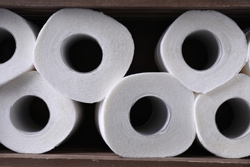 Many toilet paper rolls in wooden crate