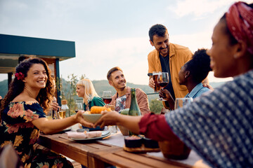 Happy man toasting with his friends during lunch party on terrace.