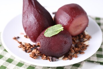 Tasty red wine poached pears with muesli on white table, closeup