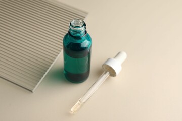 Pipette and bottle of moisturizing serum on light background, closeup