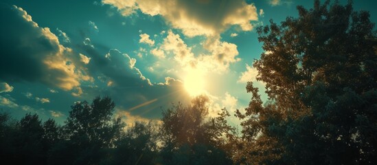 Fototapeta na wymiar Glorious sun shining through fluffy white clouds in a serene blue sky background