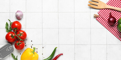 Napkin with spoon and fresh vegetables on white tile kitchen table