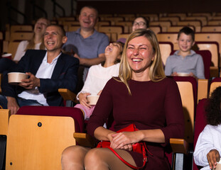 caucasian woman laughting at premiere in theatrical hall