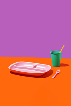 Colorful plastic tableware on vibrant background