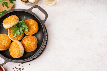 Frying pan with tasty meat cutlets on white background