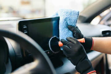Detailed car interior cleaning with brush and microfiber cloth