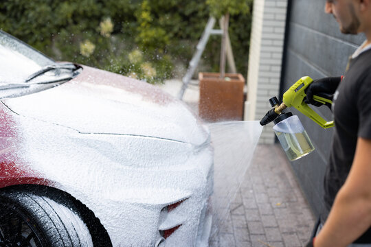 Man Cleaning Car with High-Pressure Washer