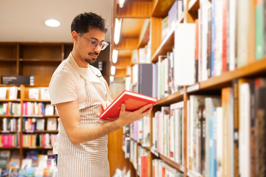 Young man browsing books in a library
