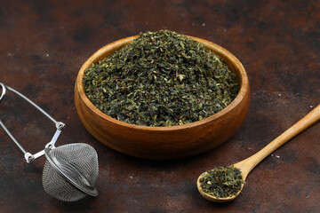 Green  tea with herbs in wooden bowl on a wooden board