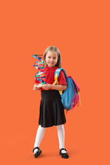 Cute little schoolgirl with DNA model and backpack on orange background