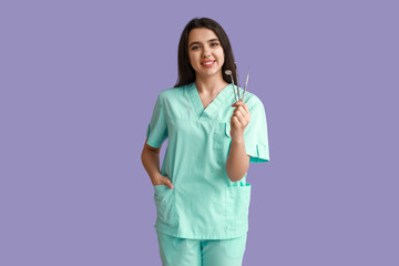 Female dentist with tools on purple background. World Dentist Day