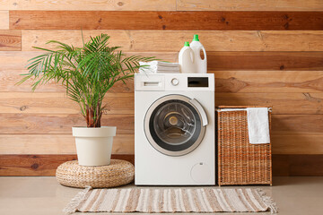 Interior of room with washing machine, palm and laundry basket - obrazy, fototapety, plakaty