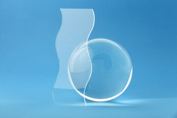 Composition with transparent glass ball on blue background