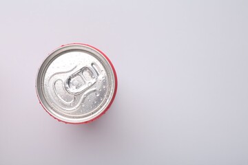 Energy drink in wet can on light grey background, top view. Space for text