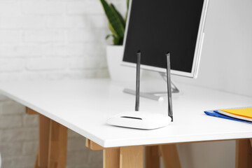 Modern wi-fi router on desk in office, closeup