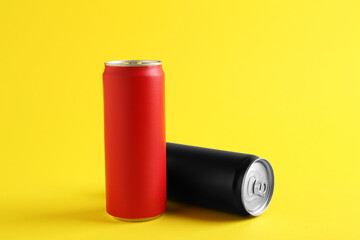 Energy drinks in colorful cans on yellow background