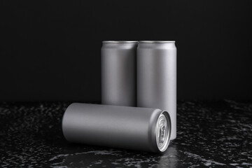 Energy drinks in cans on black textured table