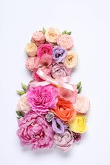 8 March greeting card design made with beautiful flowers on white background, top view