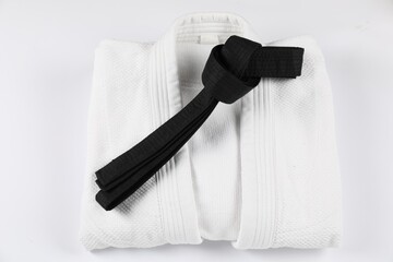 Black karate belt and kimono isolated on white