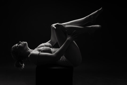 Low key portrait of beautiful female body on dark background