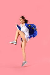 Sporty young woman with flag of European Union on pink background
