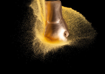 Golden Boxing glove hit sand and explode. Gold Boxer glove impact gold yellow glitter sand splash...