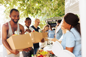Smiles and teamwork shine through as volunteers provide assistance to the homeless and individuals facing poverty. Image captures the heartwarming impact of charity and food drives.