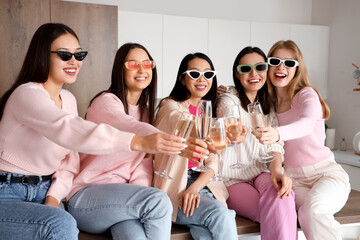 Young women with sunglasses and champagne at Hen Party in kitchen