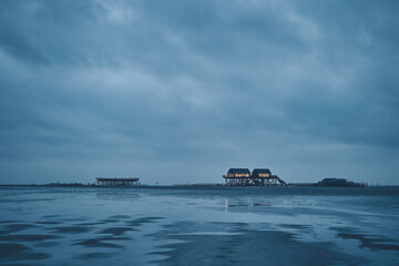 stilt house at sankt peter-ording germany on dark overcast day
