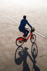 Businessman riding a bike to the sunset. Sustainable business growth, eco-friendly company concepts.