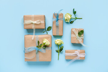 Gift boxes with beautiful white roses on blue background. International Women's Day