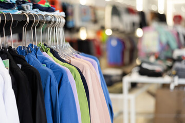 Colorful basic shirts hanging on stand in big clothing store with large assortment - 752604106