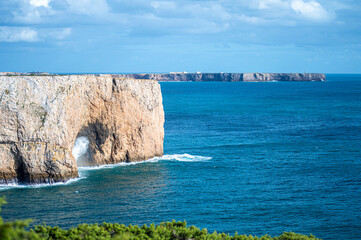 View of idyllic nature landscape with rocky cliff shore and waves crashing on. Rocks near Sagres....