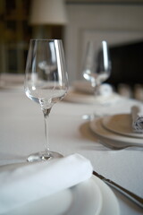 set table in an expensive restaurant, classic, empty glasses for wine,light interior fireplace on background