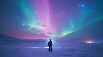 Foto op Plexiglas A person stands in snow field with beautiful aurora northern lights in night sky in winter. © Joyce