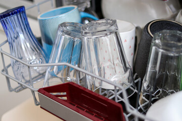 Close up of a full dishwasher with plates, cups, glassware in the kitchen 