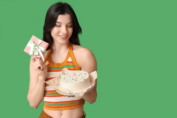 Fotobehang Beautiful young woman with sweet bento cake and gift box on green background. International Women's Day © Pixel-Shot