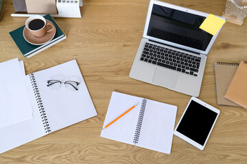Workplace with laptop, notebooks and tablet in office