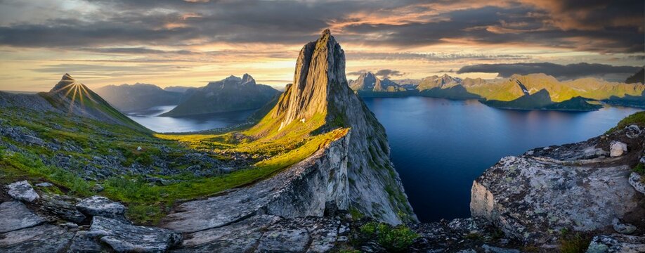 Sun rising over Bergen, dramatic clouds, morning atmosphere, steep mountain Segla, fjord Mefjorden with Bergen, island Senja, Troms, Norway, Europe