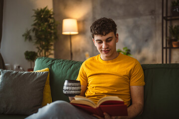 Young man caucasian teenager read book study at home education concept