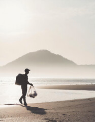 海岸ゴミを拾うボランティアの男性／環境問題・社会問題のコンセプト - obrazy, fototapety, plakaty