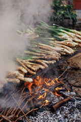 Piles of calcot, sweet onions typical Catalonia, Spain barbecue on the grill