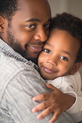 African American dad embracing his little son with love. Father's Day conceptual casual vertical portrait